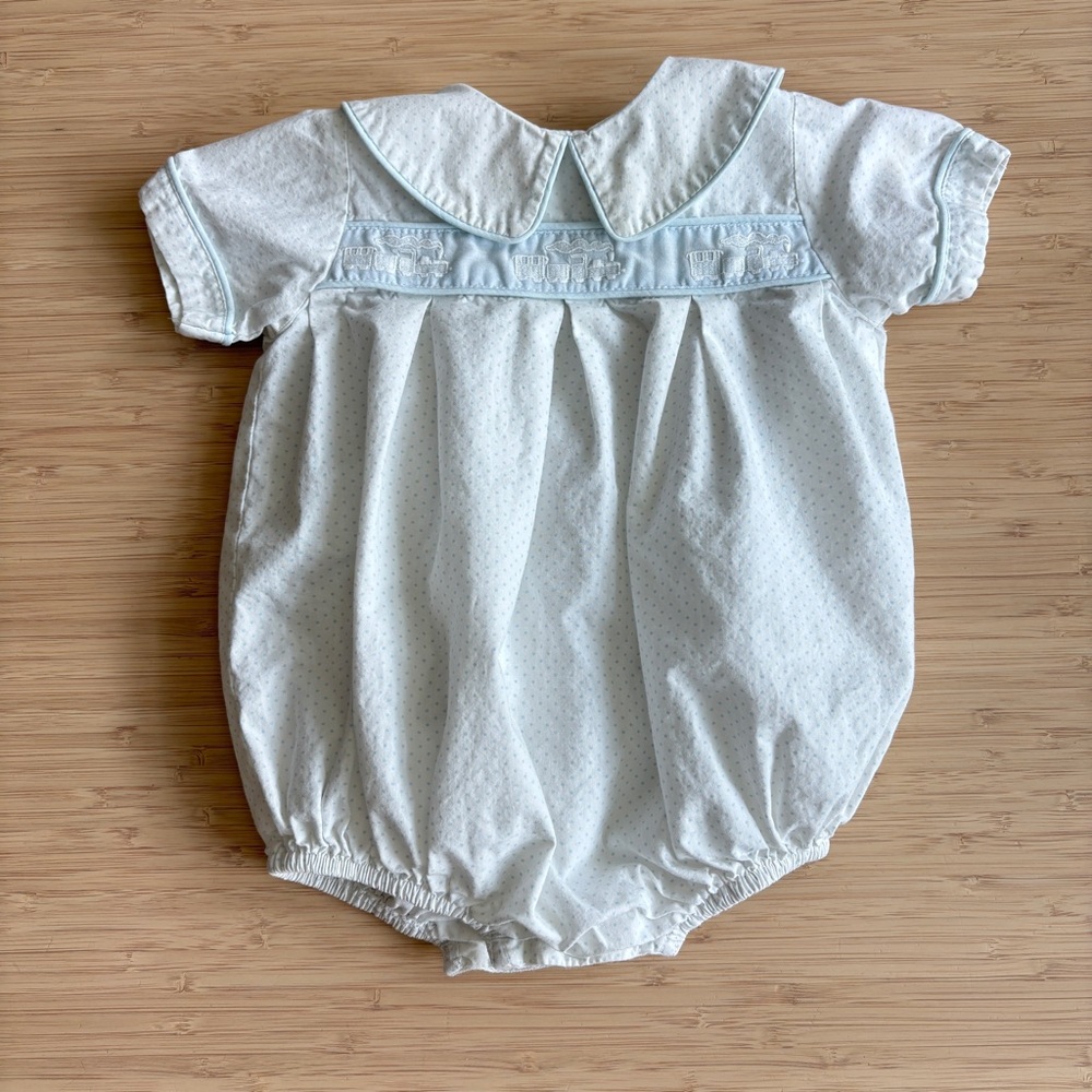 white train baby romper with blue accents